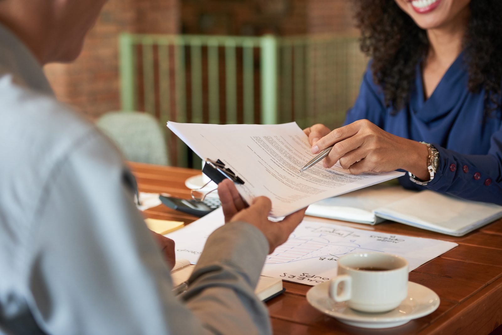 Advogada e cliente analisando um contrato durante reunião de atendimento